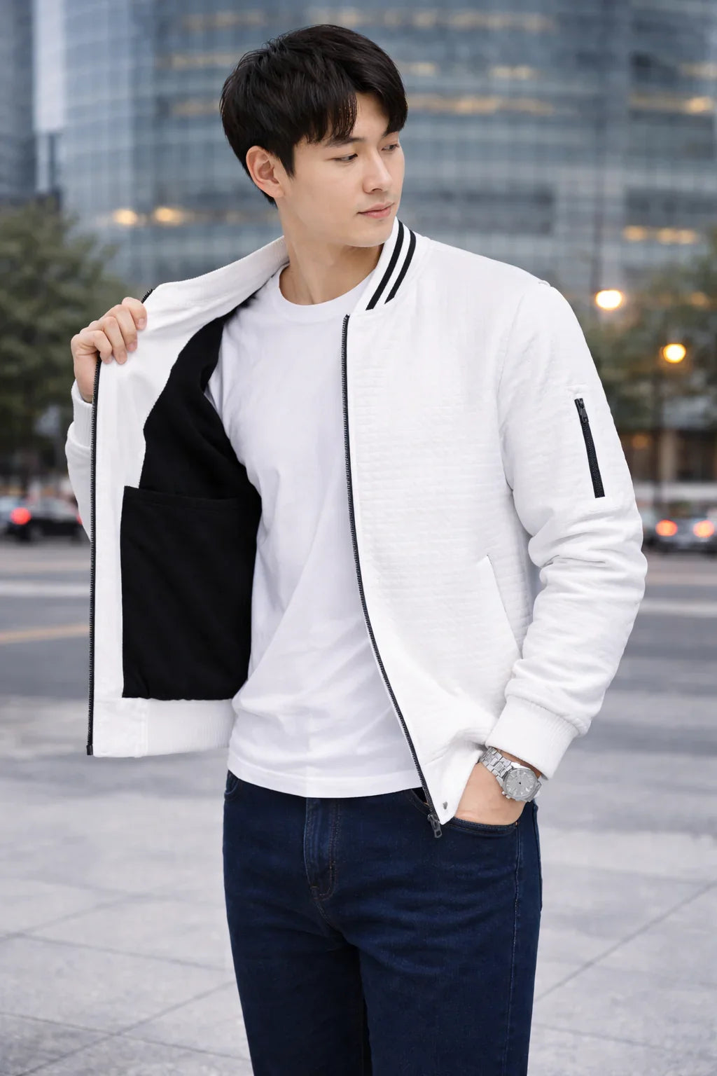 Homme portant un blouson blanc moderne, t-shirt blanc et jean, debout en ville