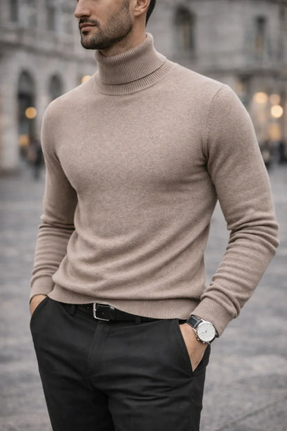 Homme portant un pull col roulé beige élégant et pantalon noir, mode masculine urbaine