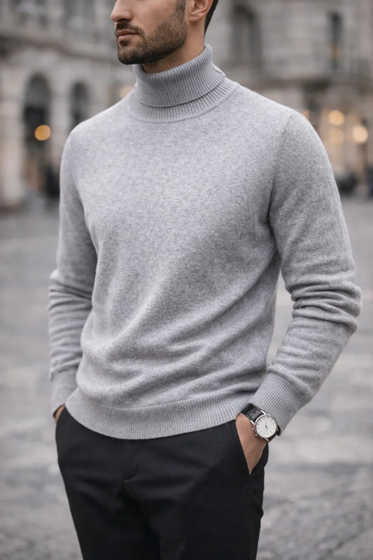 Homme portant un pull col roulé gris en laine, look élégant en ville, pantalon noir